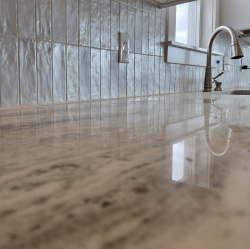 Light stone kitchen countertop and tiled backsplash